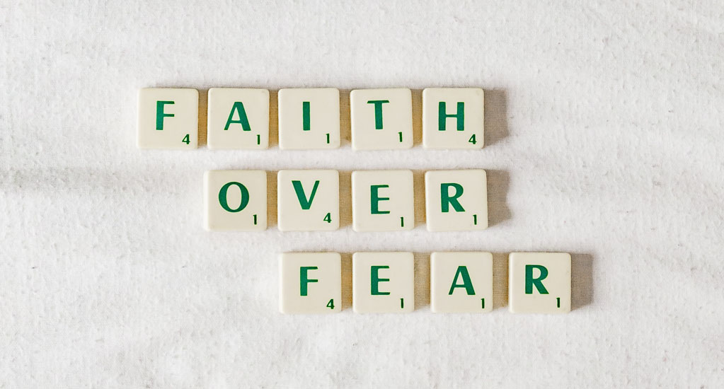 Scrabble-Steine, die den Slogan ergeben: Faith over fear